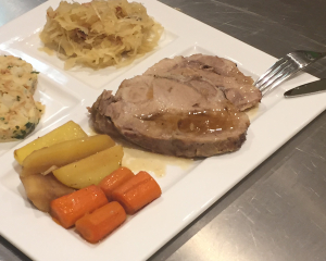 Bierschweinsbraten auf Wurzelgemüse mit Sauerkraut und Knödel