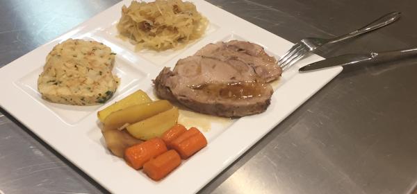 Bierschweinsbraten auf Wurzelgemüse mit Sauerkraut und Knödel